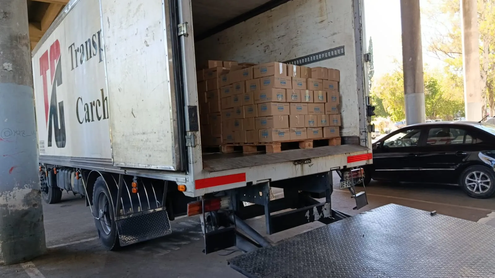 Camión de Transporte Carchedi con la pala hidráulica bajada y pallets listos para descargar